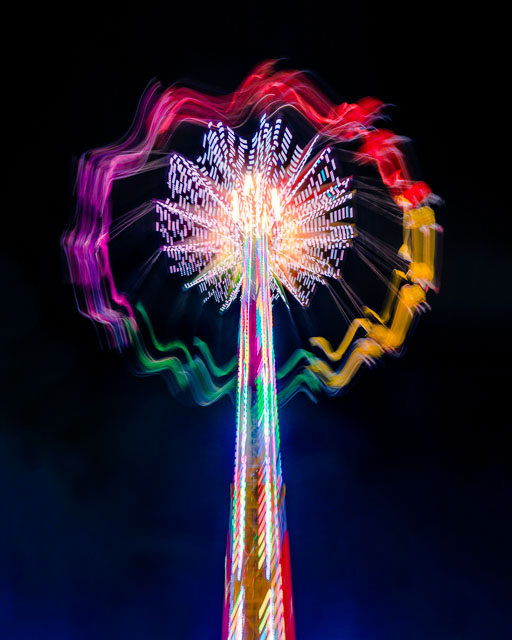 An abstract photo of a swing ride at the San Diego county fair. Motion blur makes the ride look like a giant luminescent flower.